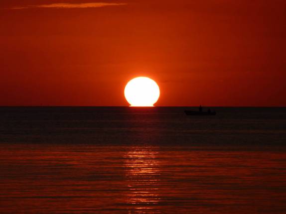 O sol toca o mar no final de tarde em Caye Caulker, na grande barreira de corais de Belize